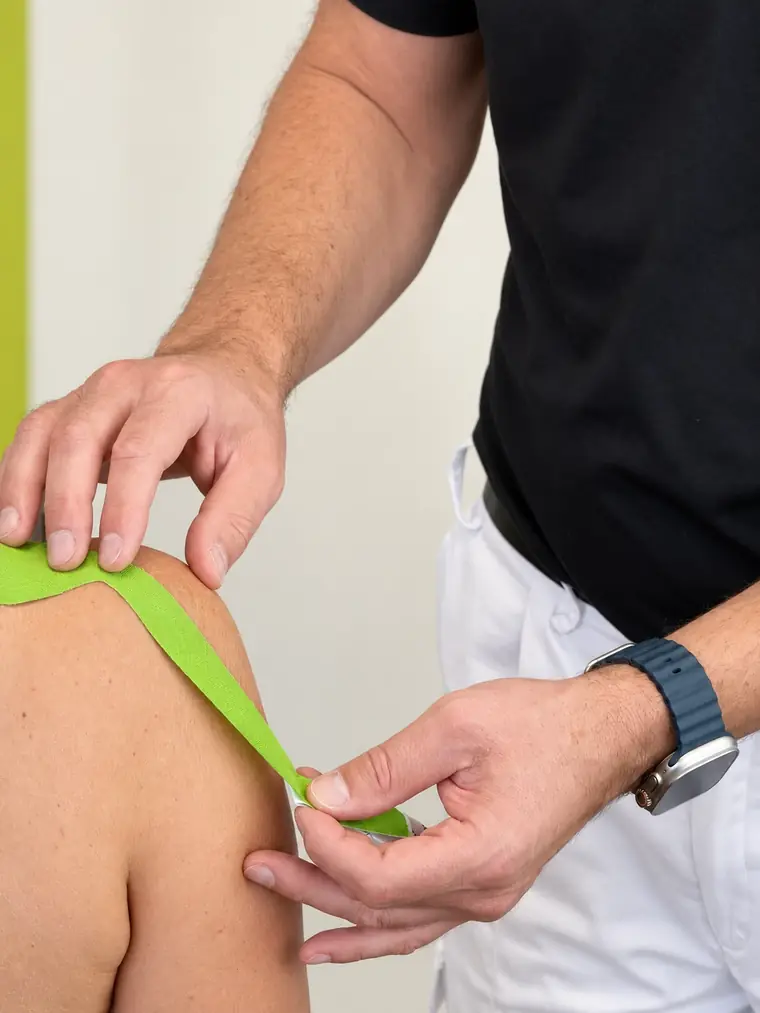 Anlegen eines Kinesio-Tapes an der Schulter